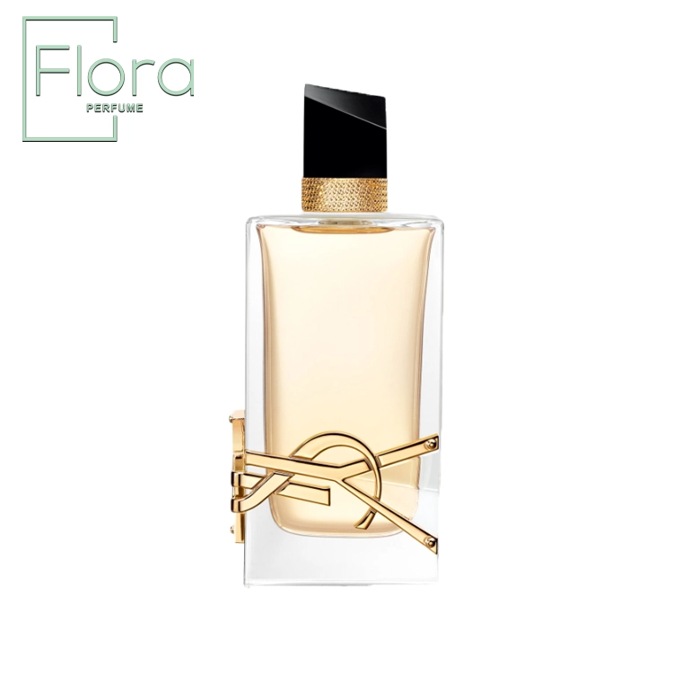 این تصویر یک بطری عطر شیک از برند ایو سن لورن (Yves Saint Laurent) را نمایش می‌دهد. بطری شفاف است و مایع طلایی رنگ داخل آن به زیبایی دیده می‌شود. درب بطری به رنگ مشکی با طراحی هندسی و ظریف است و یک نوار طلایی تزئینی در گردنه ظرف دیده می‌شود. لوگوی طلایی YSL به صورت برجسته روی بطری قرار گرفته و جلوه‌ای لوکس به آن بخشیده است.