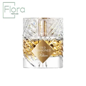 یک بطری عطر شفاف و کریستالی با طراحی پیچیده و برجسته‌، حاوی مایع طلایی درخشان. برچسب طلایی با نوشته “OLD FASHIONED by Kilian” در مرکز توجه قرار دارد.
