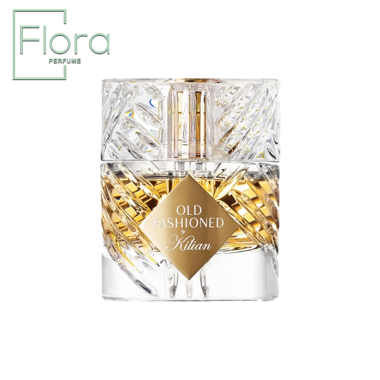 یک بطری عطر شفاف و کریستالی با طراحی پیچیده و برجسته‌، حاوی مایع طلایی درخشان. برچسب طلایی با نوشته “OLD FASHIONED by Kilian” در مرکز توجه قرار دارد.