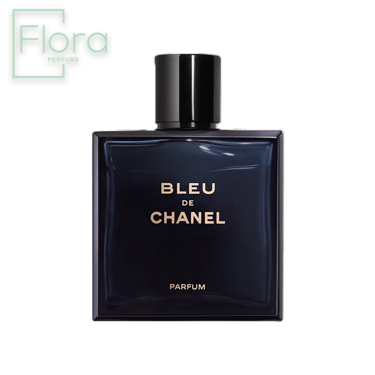 تصویری از شیشه عطر بلو شنل که به شکل مربعی و به رنگ آبی تیره است. روی شیشه، نام “BLEU DE CHANEL” با حروف سفید یا نقره‌ای نوشته شده و کلمه “PARFUM” در پایین آن قرار دارد. درب بطری به رنگ مشکی و ساده طراحی شده است. در گوشه بالا سمت چپ تصویر، لوگوی “Flora PERFUME” با رنگ سبز کمرنگ دیده می‌شود.