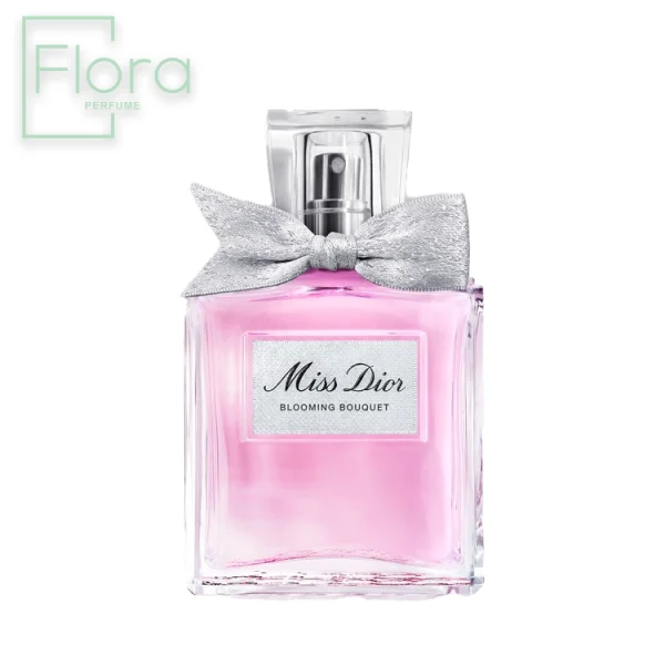 شیشه عطر میس دیور بلومینگ بوکت با طراحی ظریف و زنانه خودنمایی می‌کند. شیشه مستطیل شکل شفاف با مایع صورتی رنگ در داخل، با یک پاپیون نقره‌ای براق که دور گردن شیشه گره خورده است، تزئین شده. بر روی شیشه، نام “Miss Dior” با خطی زیبا و عبارت “Blooming Bouquet” با فونت ظریف‌تر به چشم می‌خورد. لوگوی Flora Perfume نیز در گوشه سمت چپ بالای عکس دیده می‌شود.